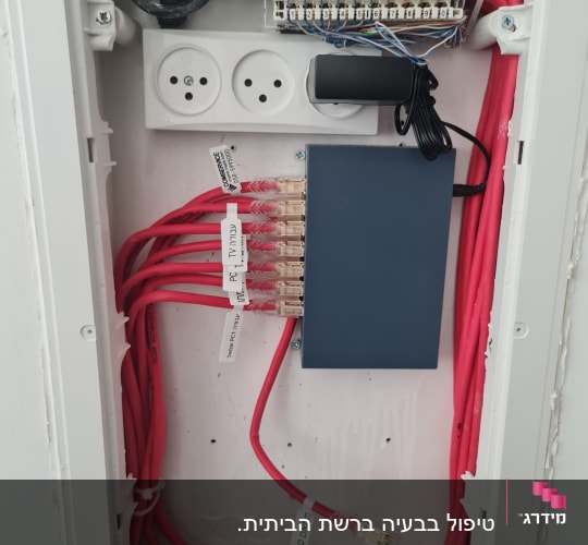 ארון תקשורת עם כבלים אדומים ומחבר רשת